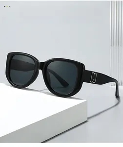 Detail of glossy black cat-eye sunglasses featuring silver metal accents on the temple