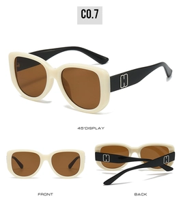 Detail view of cream vintage oversized sunglasses featuring a gold H-shaped temple logo