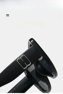 Macro detail of glossy black sunglass frames with silver metal hinge and logo detail