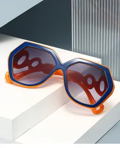 Détail de lunettes de soleil hexagonales bleu et orange avec des branches à maillons ajourés