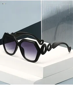 Vue détaillée des branches incurvées ajourées sur des lunettes de soleil hexagonales noires