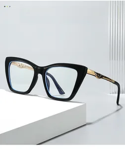 Detail of black cat-eye frames with golden metal temples and geometric hollow patterns