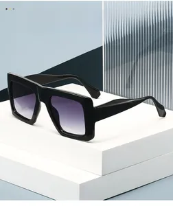Detail view of large square sunglasses with black frames and purple gradient lenses