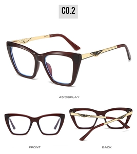 Detail of burgundy cat-eye glasses frame with golden metal temples and embossed floral art