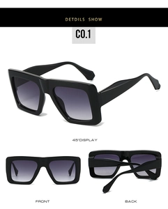 Detail view of large square sunglasses showing front and side profile in glossy black