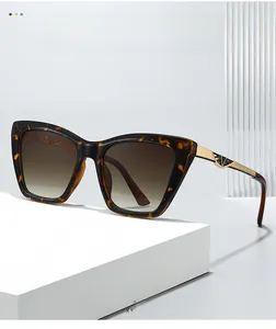 Close-up of cat-eye sunglasses featuring tortoiseshell frames and gold hollow-out temples