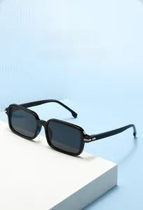 Detail of black square sunglasses with silver metal hinges on a geometric white stand