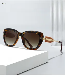Detail of dark tortoiseshell sunglasses with gradient lenses and gold metal temple accents