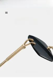 Detail of lightweight rimless sunglasses with gold textured temples and grey lenses