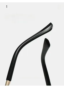 Macro detail of glossy black rimless sunglasses temples with gold hinges and curved design