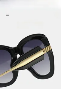 Macro detail of cat-eye sunglasses featuring golden metal hinges and gradient lenses