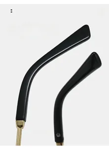 Detail of curved black mirror legs and golden metal hinges on cat eye sunglasses