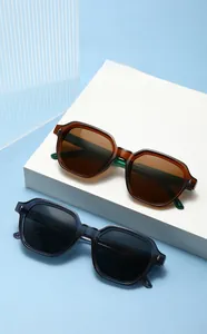 Retro polygon sunglasses with translucent frames and metallic stud details on blue background