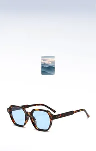 Detail of tortoise shell sunglasses with light blue lenses and silver rivet accents
