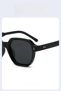 Macro shot of black acetate sunglasses frame featuring silver lightning metal logo and rivets