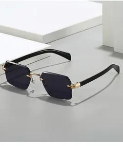 Détail de lunettes de soleil carrées sans monture avec verres gris et branches dorées