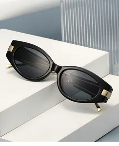 Detail of 2025 cat eye glasses with wide black frames and gold metal hinge accents