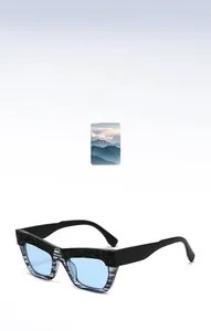Detail of cat eye sunglasses with black frame, light blue lenses and textured wavy pattern