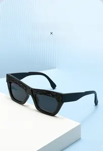 Detail of trendy square sunglasses with unique wavy textured black frames and dark lenses