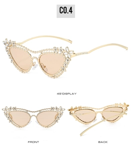 Dettagli di occhiali da sole cat-eye dorati con strass a fiori bianchi e lenti sfumate