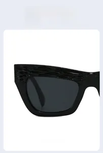 Close-up of black oversized cat eye sunglasses featuring unique textured frame carving details