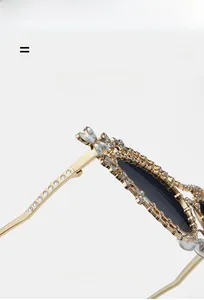 Dettaglio macro di occhiali da sole cat-eye di lusso con montatura in metallo e strass oro