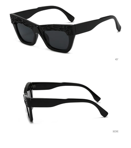 Detail view of black square sunglasses showing 45-degree and side embossed texture frames