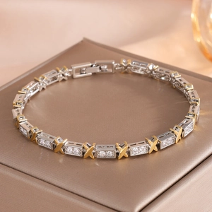 Detailed macro view of X-shaped gold links with micro-paved white zircons on a luxury bracelet