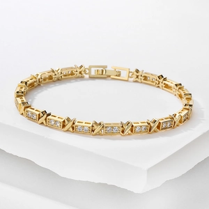 Close-up of gold-plated X-shape bracelet with sparkling zircon stones and folding clasp