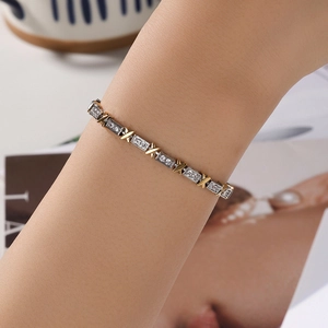 Elegant gold and silver X-shaped link bracelet with sparkling cubic zirconia on female wrist