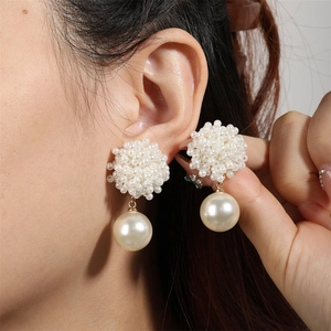 Close-up of French vintage faux pearl drop earrings with elegant beaded clusters on model