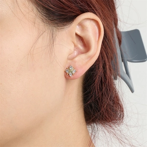 Vue rapprochée de boucles d'oreilles minimalistes en X dorées avec cristaux