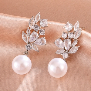 Elegant teardrop pearl earrings with leaf-shaped zirconia on silk background