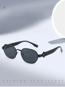 Détail de lunettes de soleil hexagonales noires avec motifs de losanges ajourés sur les branches