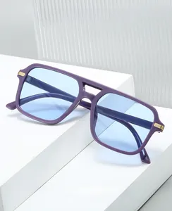 Detail of purple square glasses with blue lenses and gold metal accents on a white stand