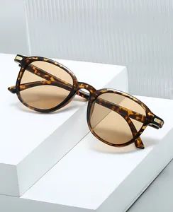 Detail of tortoise shell oval glasses with metal accents on a white geometry block