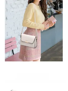 Detail view of the back anti-theft zipper pocket on this beige minimalist crossbody bag