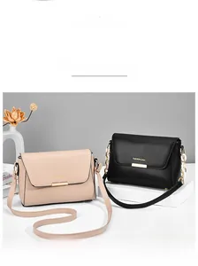 Detail of minimalist leather shoulder bags in nude pink and black with golden buckles