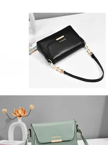 Detail of the minimalist handbag featuring a metal lock buckle and elegant chain strap