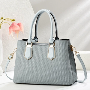 Litchi pattern light blue tote bag with top handles and golden hardware in studio setting