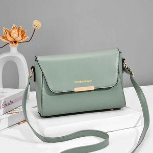 Minimalist mint green faux leather shoulder bag with gold metal buckle on white pedestal