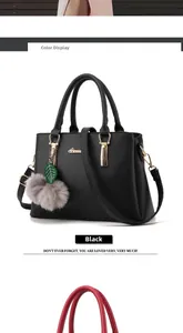 Détail du sac à main noir en similicuir avec fermoirs dorés et pompon décoratif