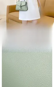 Vue macro de la texture du cuir grainé et sac bandoulière vert sauge avec boucle dorée