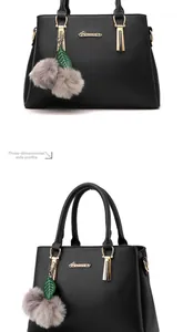 Détail du sac à main noir mat avec logo métallique et pendentif en peluche grise