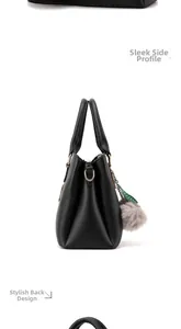 Vue latérale du sac à main en cuir mat noir avec détails dorés et pompon décoratif