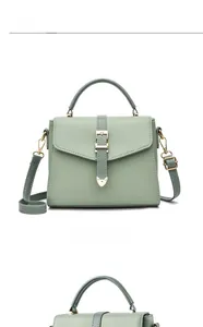 Détail du sac à main en cuir grainé vert clair avec fermoir doré et bandoulière