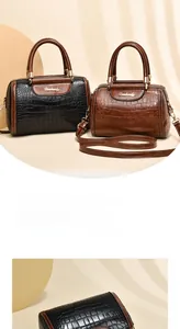 Detailed view of the crocodile embossed texture and metallic zipper of the crossbody bag