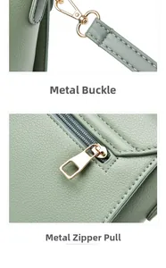Détail des boucles métalliques dorées et de la fermeture éclair sur sac en cuir vert clair
