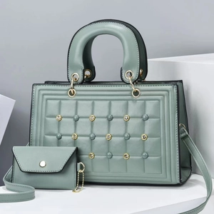 Detalle del bolso shopper acolchado verde salvia con tachuelas metálicas y sobre a juego