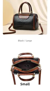 Detail of crocodile pattern Boston bag with interior compartments and gold hardware